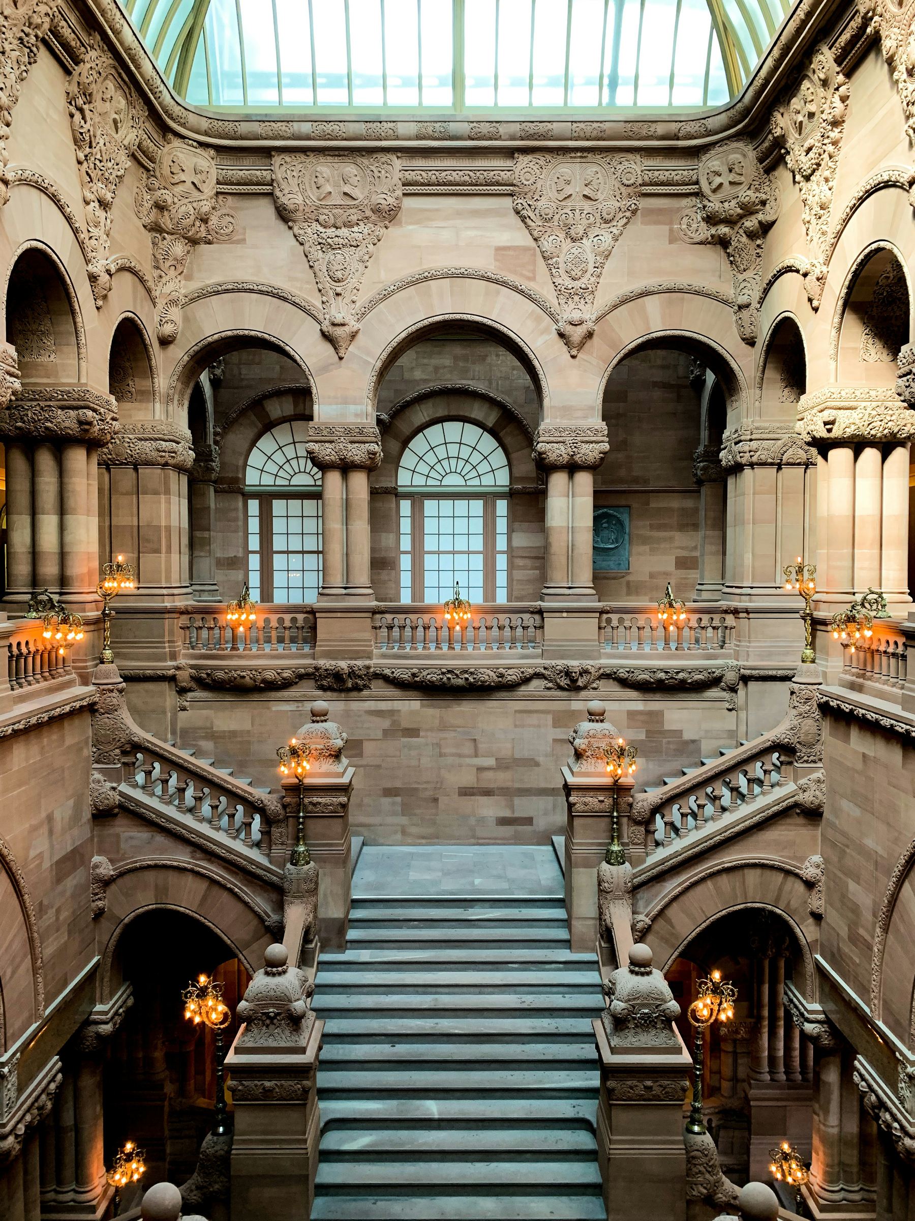 Stone staircases and carved arches inside the New York State Capitol.
